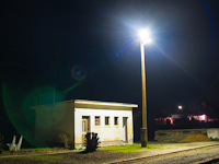 An illuminated warehouse at Acsa-Erdőkürt stop