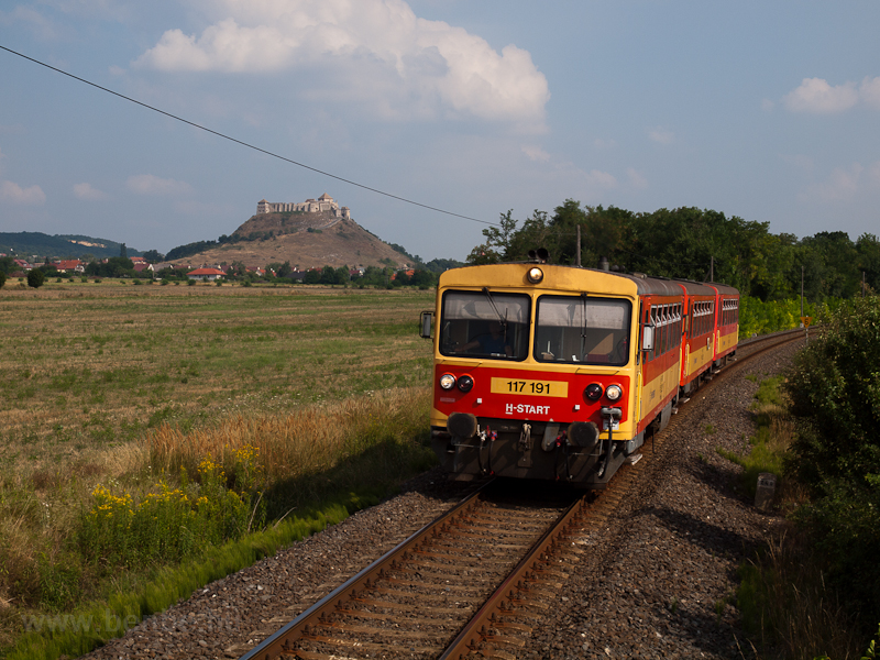 The MÁV-START 117 191 is seen between Sümeg and Nyírlak with the fortress of Sümeg in the background photo
