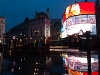 Emeletes busz a Piccadilly Circusön a legendás fényreklámokkal és egy metrólejárattal
