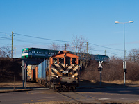 A MÁV-REC 449 028 konténervonatot húz ki Szabadkikötőből Soroksári útra, a háttérben a Csepeli HÉV MX/A vonata
