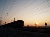V63 016 with a freight train under the rising sun at Vámosgyörk
