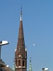 A Boeing 737-800 next to the tower of the Szilágyi Dezsõ tér church