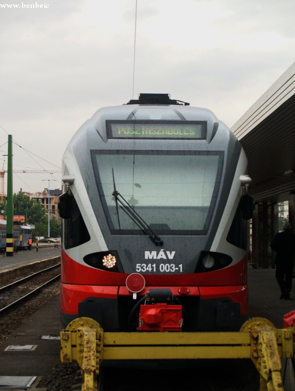 Legalábbis a kiírás szerint: a gyakran felmerülő "miért nem mennek vonattal a vasúti sajtótájékoztatóra"-gondolat jegyében a Stadler magát az utazást is a program részének tekintette, így a regisztrációt is a Déli pályaudvarra hirdette meg. Aki regisztrált, az ingyen kapta a vonatjegyét is a hostessektől (l. később). A vonat egyébként Sárbogárdra tartott, de mivel aki számított, az Pusztaszabolcsra ment, így kivételesen azt írták ki a helyesen működő kijelzőkre. kép 5341 003-1 készül elindulni Pusztaszabolcsra fotó