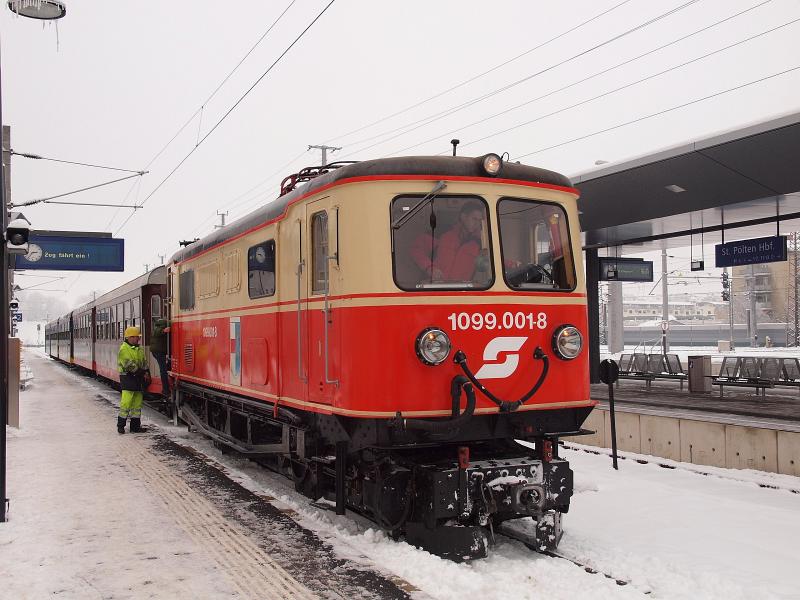 A hattengelyes, csatlórudas hajtású, csökkentett frekvenciás, de nem szabvány ÖBB-delejjel működő gép hivatalosan a világ legöregebb, napi forgalomban résztvevő villanymozdonya, egészen pontosan 1911-ben gyártotta a Krauss & Tsa. valamint a Siemens-Schuckert művek (előbbi a járműszerkezetet és az erőátvitelt, utóbbi a villamos gépeket szállította). Ha nem hiúsul meg a járműbeszerzés (meglepődnék, ha nem kép Az ÖBB 1099.001-8 pályaszámú ős-villamosmozdonya St. Pölten Hauptbahnhof állomáson fotó