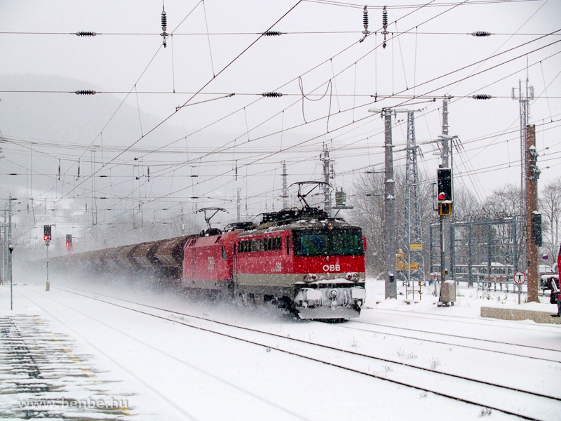 An unidentified BB class 1142 is acting as a bank engine at the head of a heavy freight train pulled by a Taurus across Payerbach-Reichenau station photo