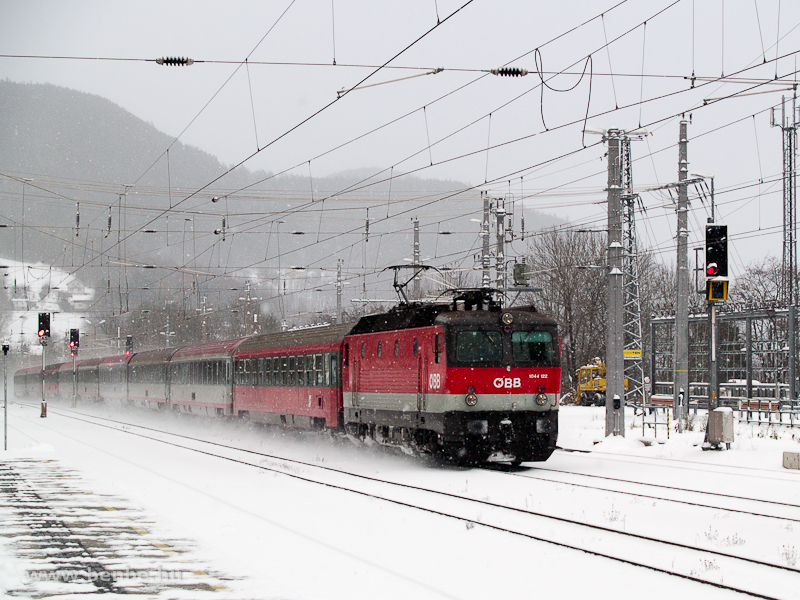 The BB 1044 122 is passing Payerbach-Reichenau station with a Sdbahn fast train in heavy snowfall photo