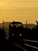 A MÁV-Trakció M47 1305 pályaszámú tolatómozdonya a naplementében Tokod és Dorog állomások között a párhuzamos egyvágányú szakaszon a Tokod - Esztergom-Kertváros vonal mellett