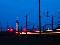 A Praterstern vasútállomás éjszaka. Éppen egy vonat jár be Handelskai felől, a háttérben a Millennium Tower látszik.