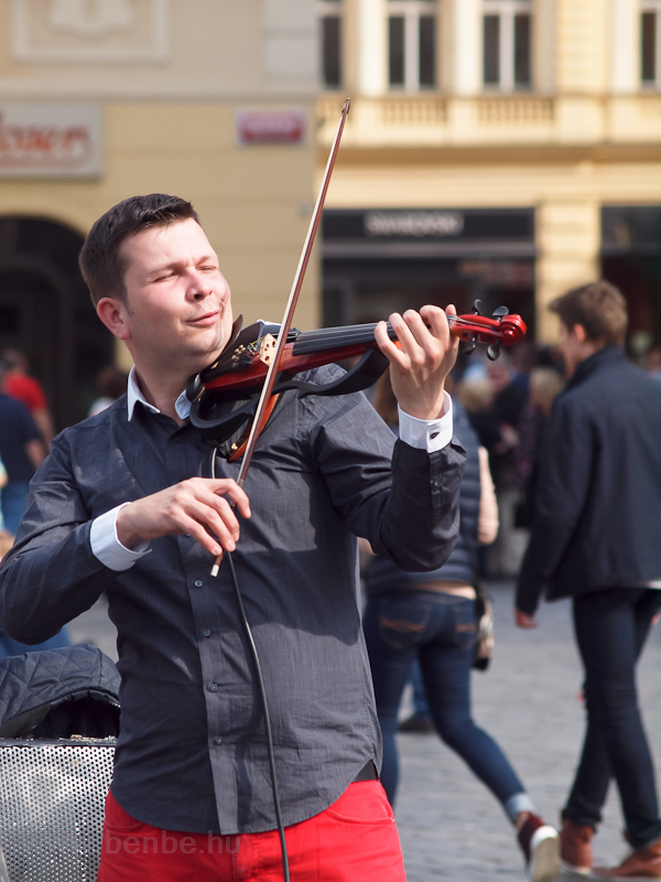 A violinists plays with big photo
