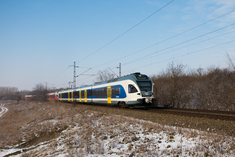 A MÁV-START 415 114 pályaszámú, kék Stadler FLIRT motorvonata csatolva két piros FLIRT-tel Herceghalom és Biatorbágy között
 fotó