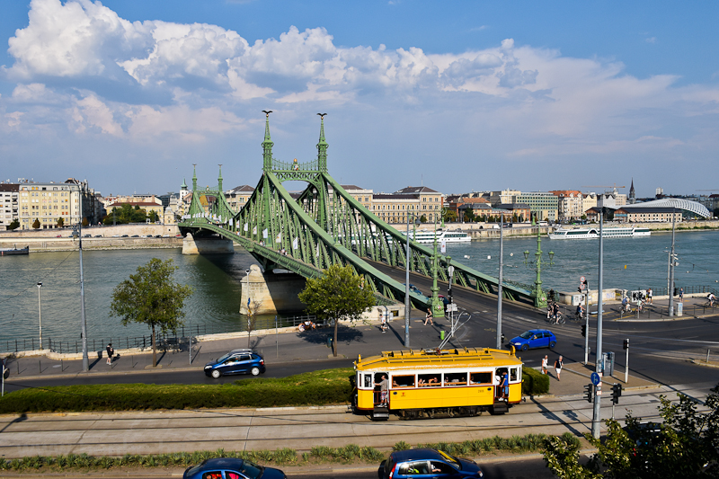 The BKV wood frame historic tram number 2806 is seen in its last operating condition and livery at Szent Gellrt tr with Szabadsg-hd (Liberty bridge), Corvinus Univeristy of Economics, the Duna (Danube) river and hotel boats in the background photo