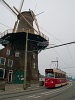 Hágai villamos egy szélmalom mellett Delftben
