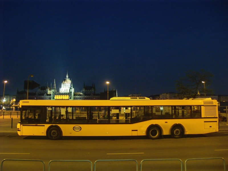 A Volnbusz serving as a suburban train replacement bus at Budapest, Batthyny-tr with the Hungarian Parliament in the background photo