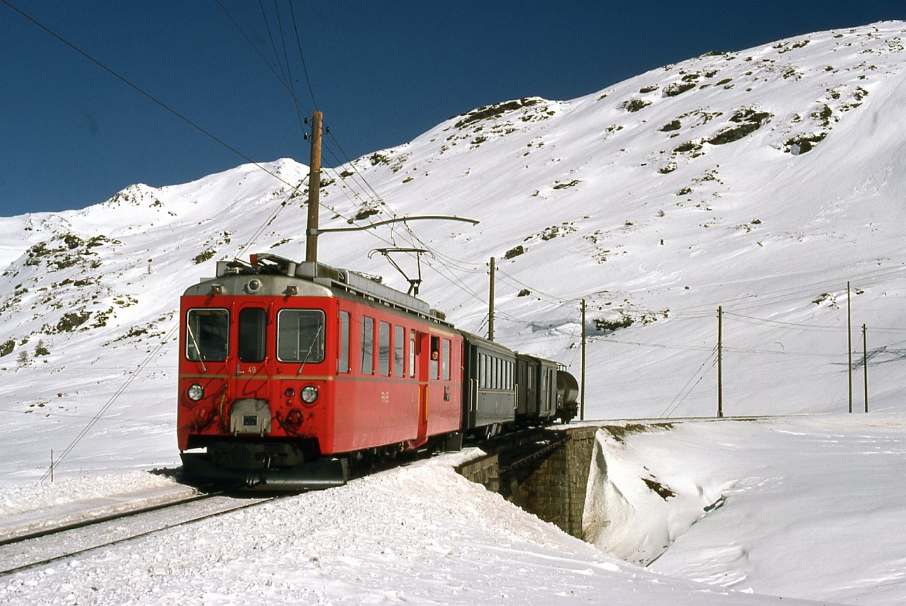 The RhB ABe 4/4 II 49 of the Berninabahn between Ospizio Bernina and Bernina Diavolezza with a mixed freight/passenger train photo