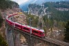 The Rhtische Bahn ABe 8/12 3509 seen between Filisur and Alvaneu at the Schmittentobel-Viadukt extended by Swiss Post containers as a PmG (Personenzug mit Gterbefohrderung)