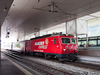Az MGB HGe 4/4<sup>II</sup> 106 <q>St. Gotthard / S. Gottardo</q> Disentis/Mustér állomásról indul egy Glacier-expressz vonattal Zermattba