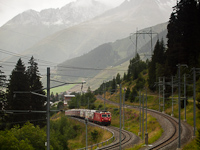 The MGB HGe 4/4<sup>II</sup> 104 is pulling a freight train out of the Las Rueras site of the Gotthard Base Tunnel construction to the main line of the Oberalppasstrecke